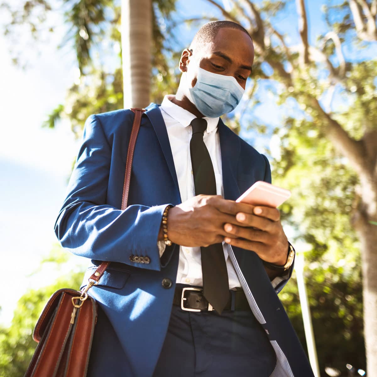 mobile businessman wearing a mask during covid crisis